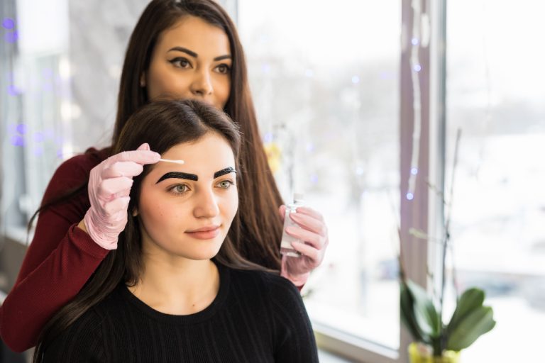Beautician styling a client's eyebrows