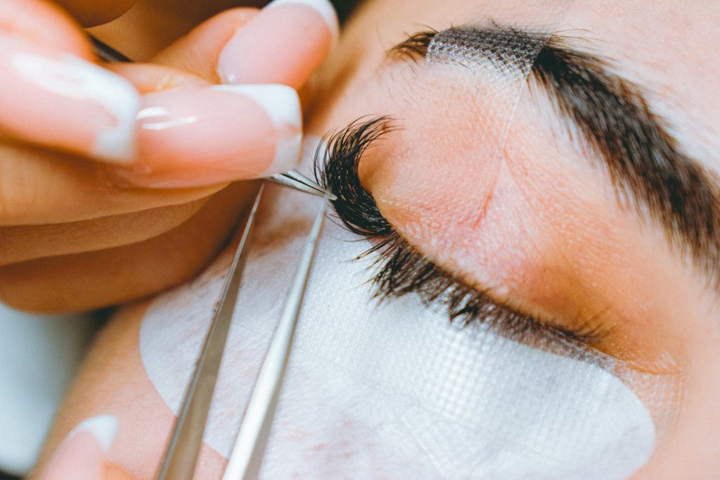 Eyelash extensions being applied with tweezers