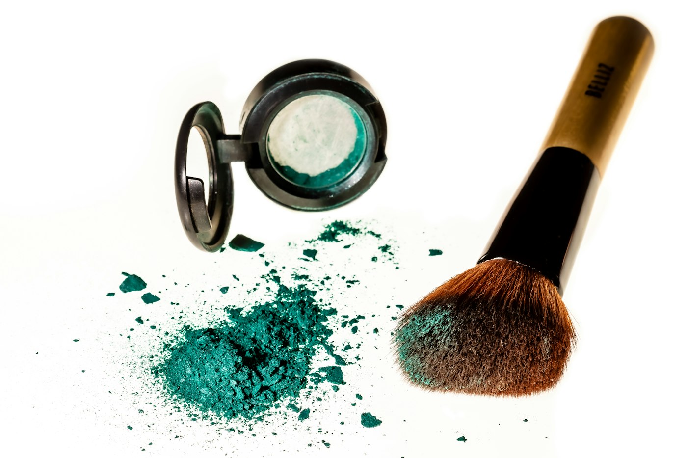 Makeup brush and eyeshadow on a white background